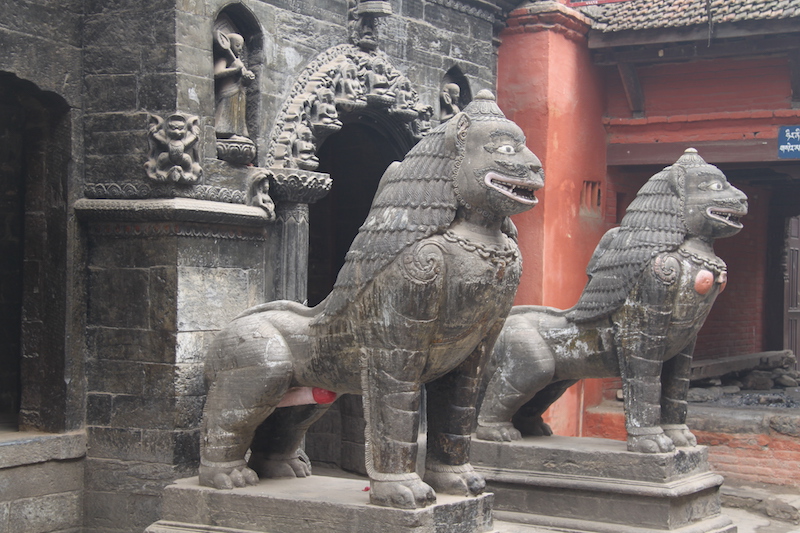 I due leoni guardiani del tempio d'oro a Patan antica capitale nella valle di Kathmandu in Nepal