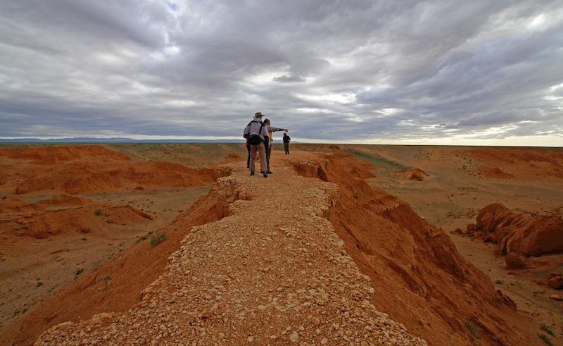 turisti a passeggio al tramonto  sulle fiammeggianti falesie di Flaming Cliffs a Bayanzag nel deserto del Gobi in Mongolia